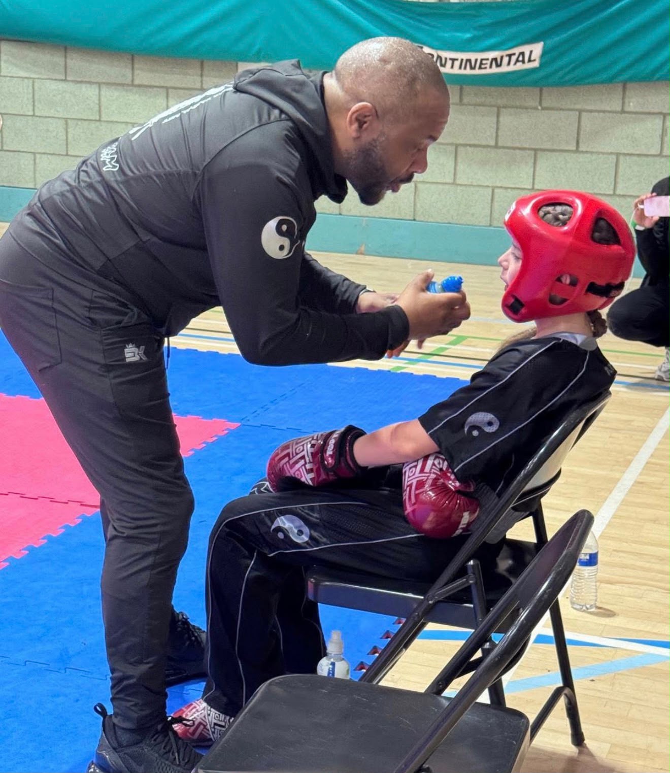 Head Instructor Peter Felix coaching a young fighter between rounds