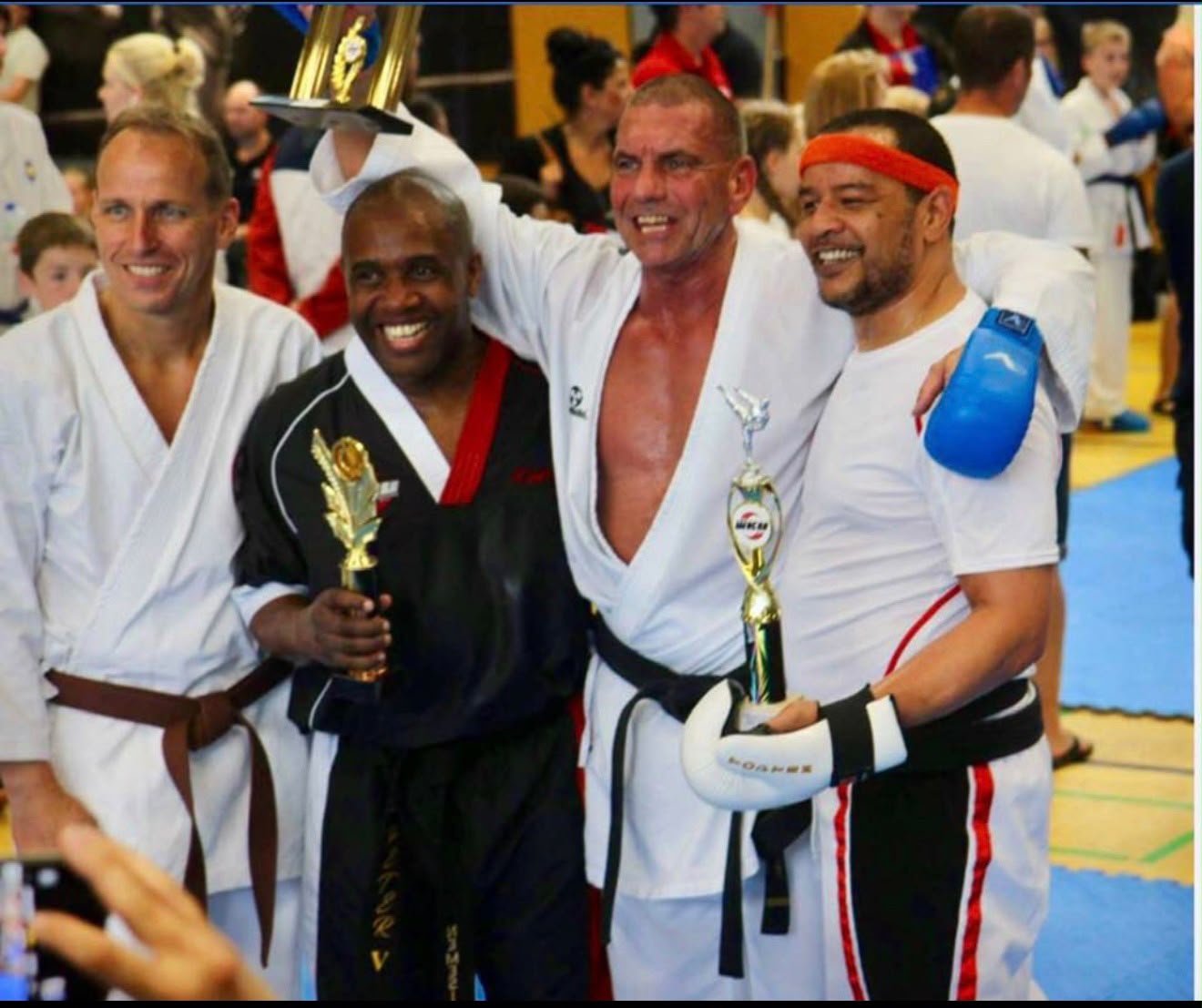 Coaches celebrating with trophies at a championship